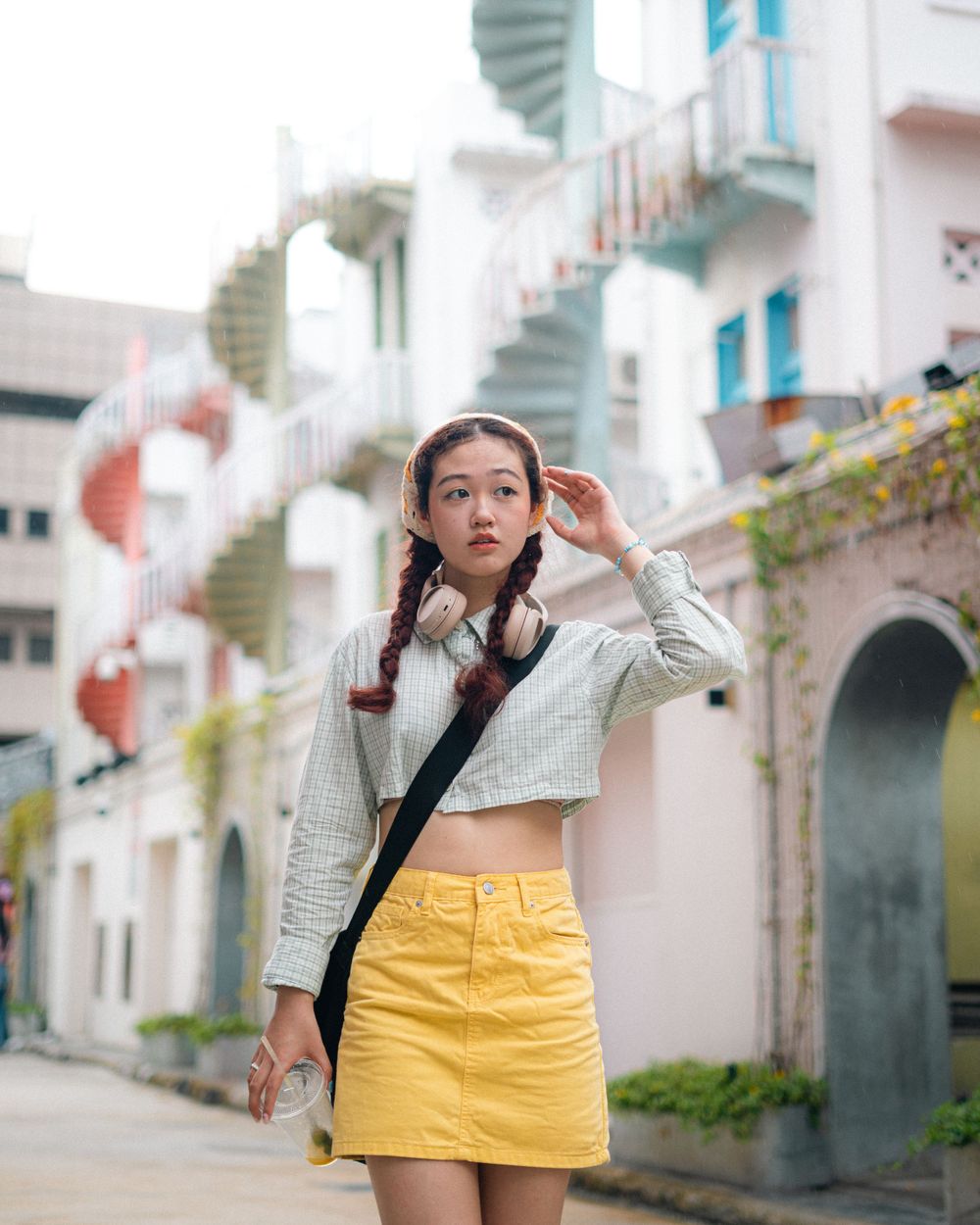 Vintage-inspired outfit against pastel buildings with spiral staircases in the background.
