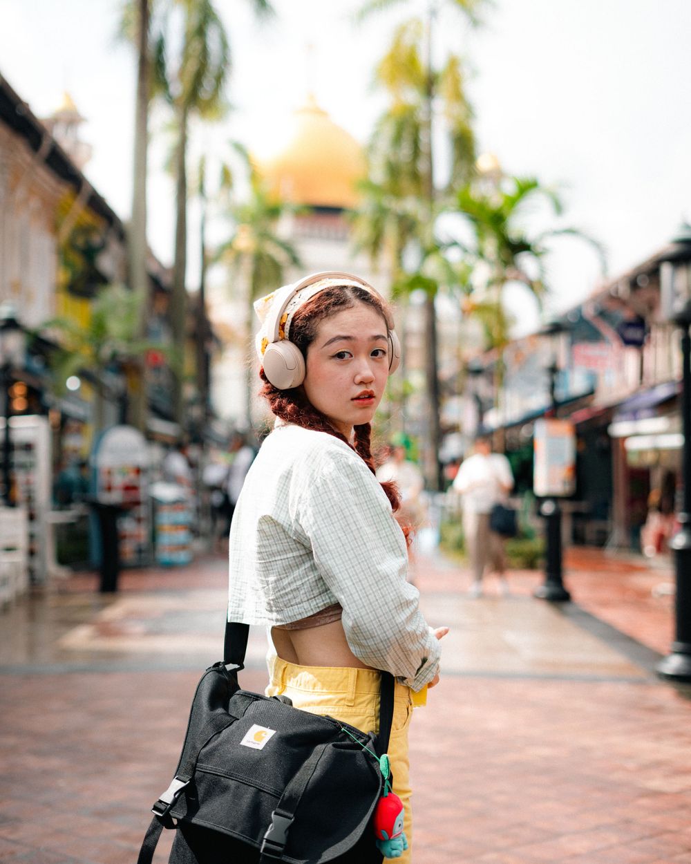 Trendy street style photography with palm trees and tropical urban setting.