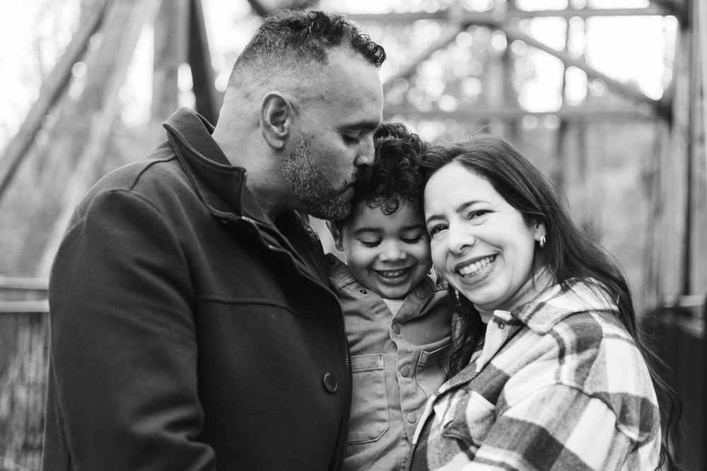 A romantic couple shares tender moments in black and white photos during an outdoor engagement photoshoot.