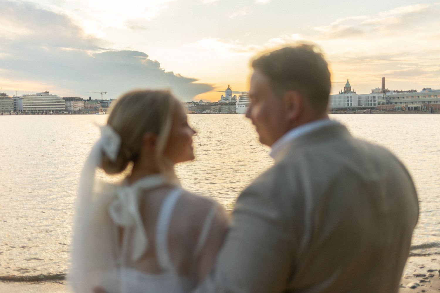 Romantic sunset waterfront portrait with couple in soft golden light.