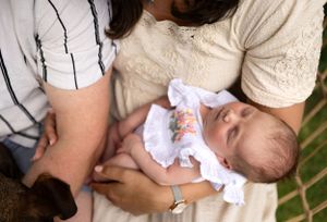 Peaceful newborn baby sleeping while being cradled in caregiver's arms.