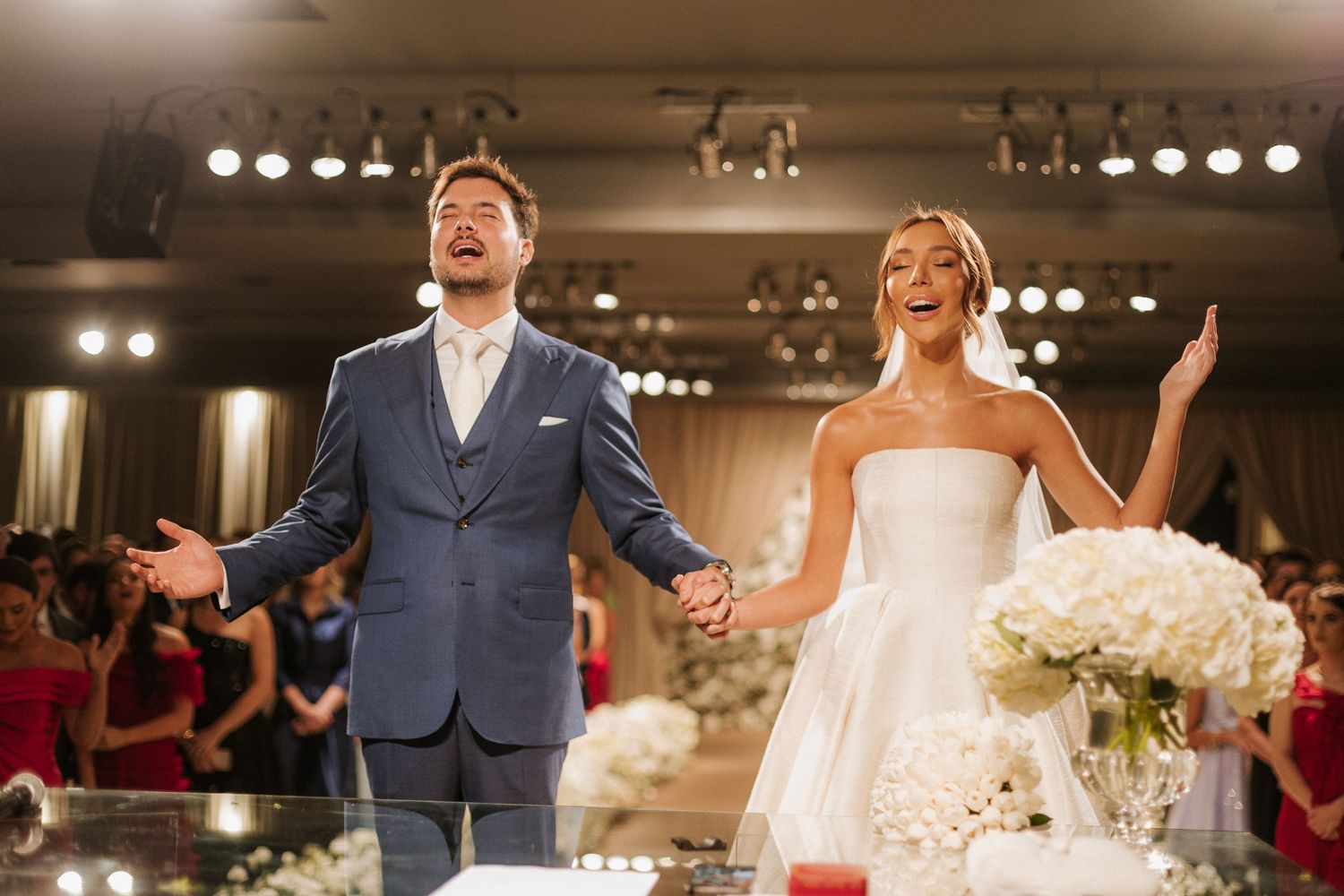 Wedding reception celebration in an elegant ballroom with dramatic lighting and decor.