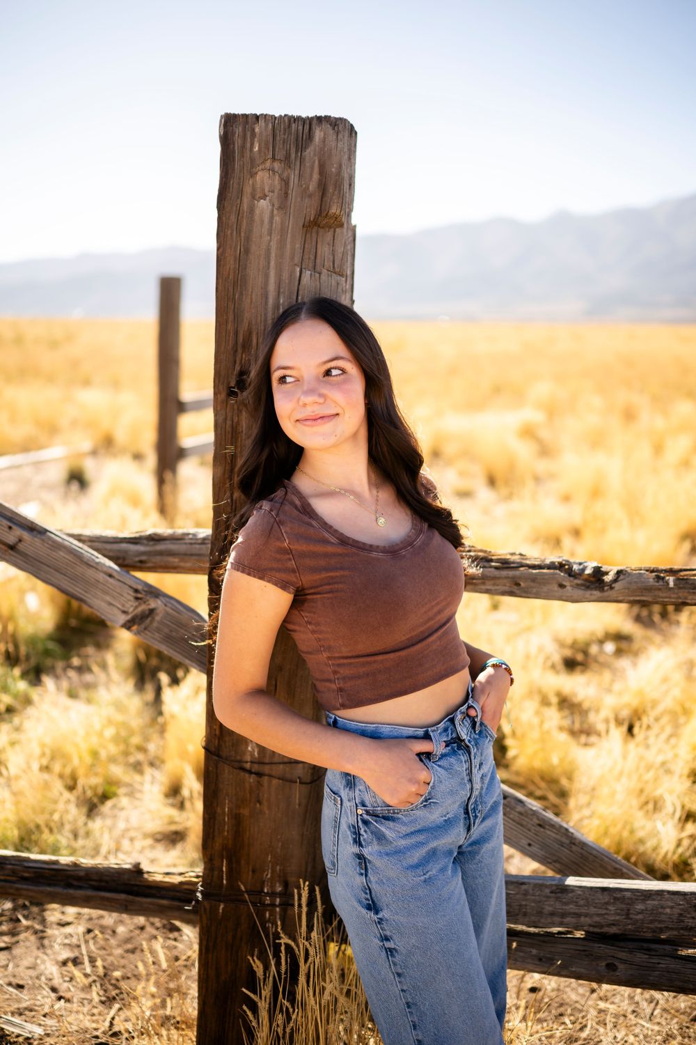 Casual portrait series by a rustic wooden fence in warm evening light.