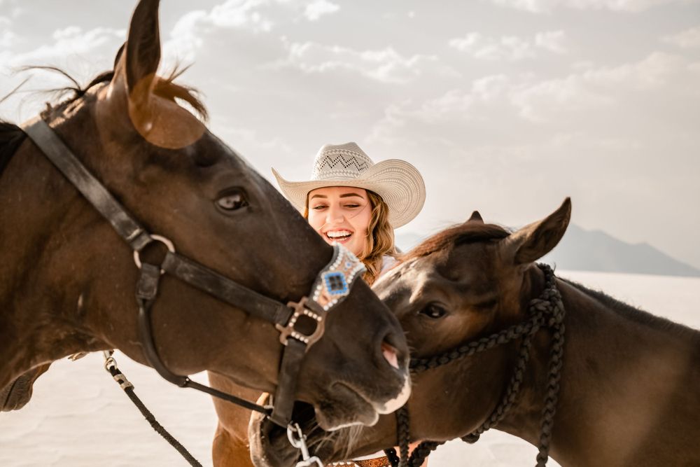 Western style portrait with two horses against mountain landscape.