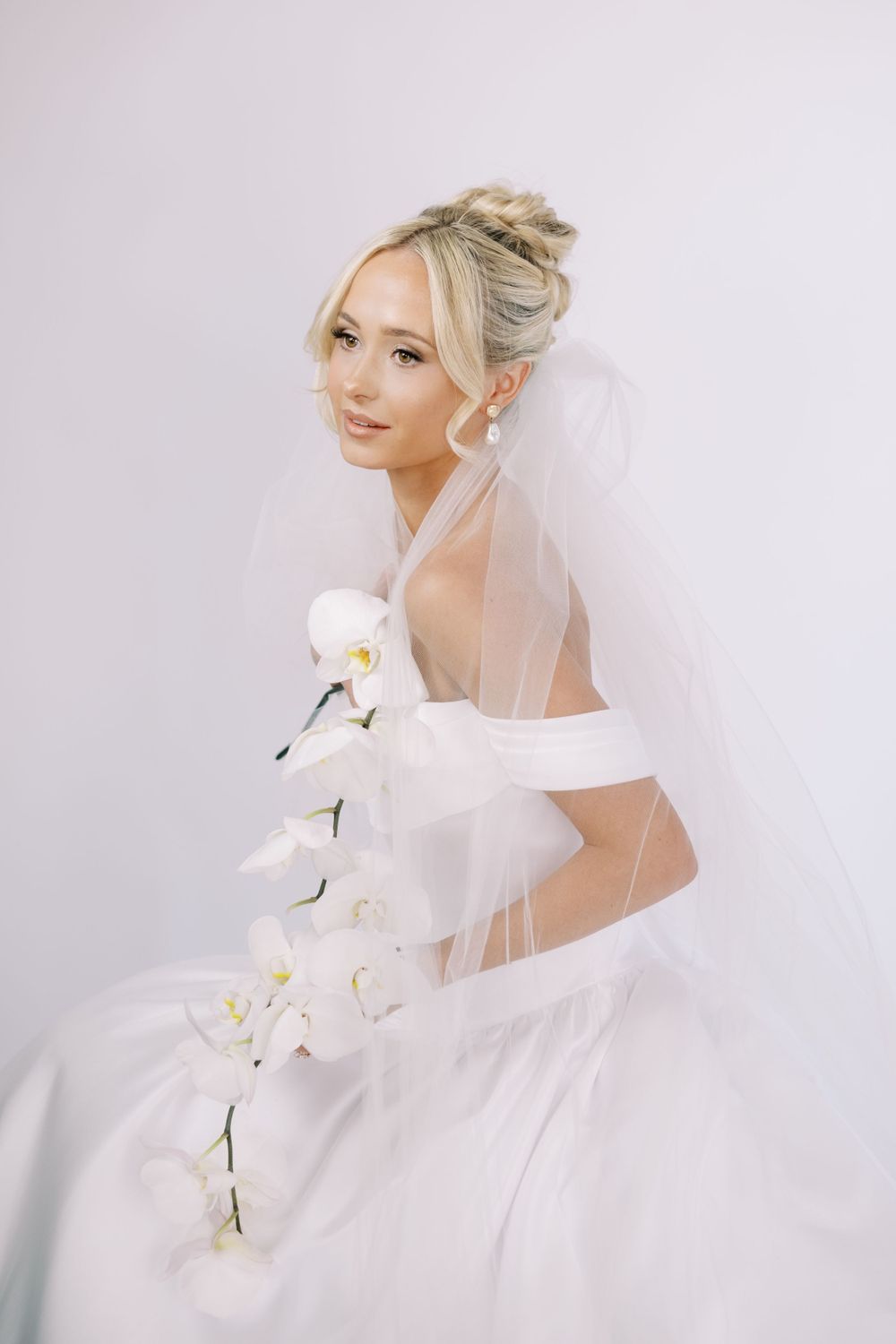 Romantic bridal series featuring ethereal veil movement and white orchid bouquet.
