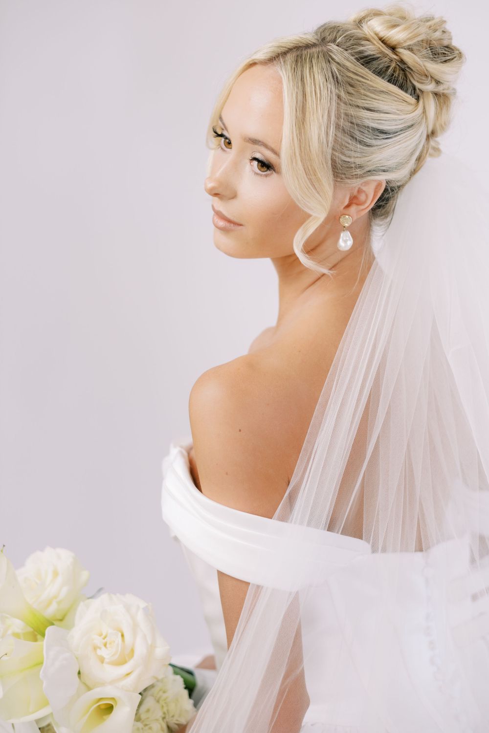 Delicate bridal portraits showcasing upswept hairstyle and flowing veil details.