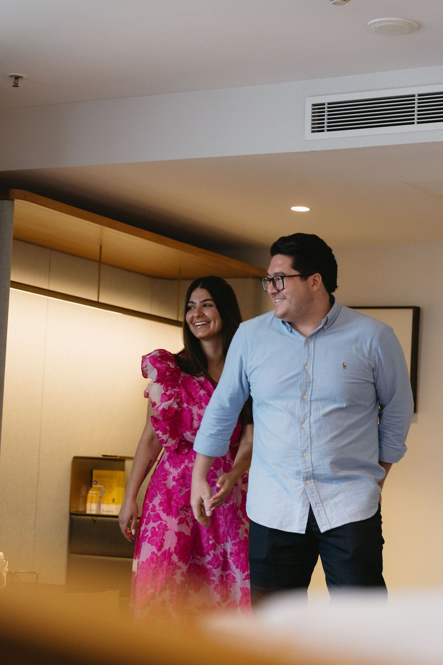 A couple in coordinated outfits sharing a joyful moment indoors.