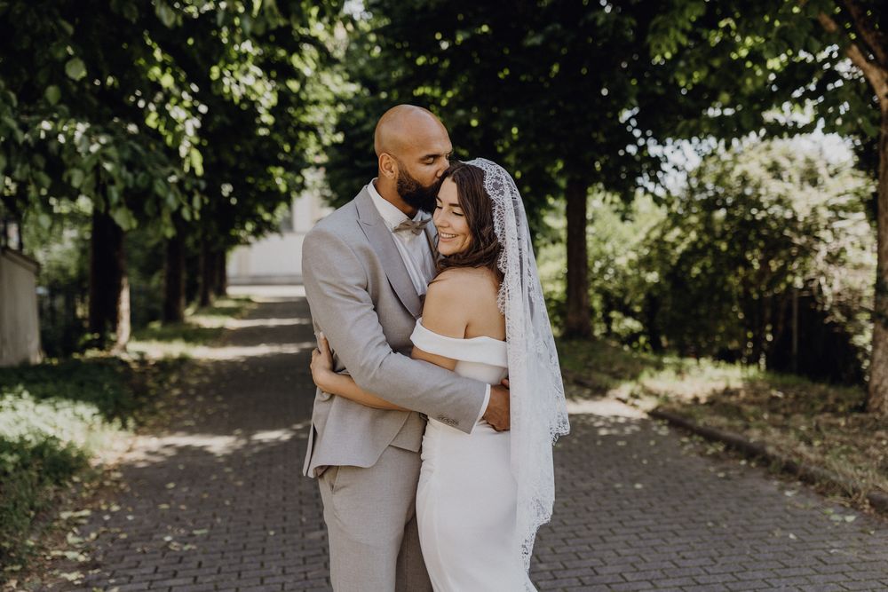 Brautpaarshooting einer Hochzeit in Dossenheim, das Paar küsst sich vor der katholischen Kirche in Dossenheim nach der Trauung.
