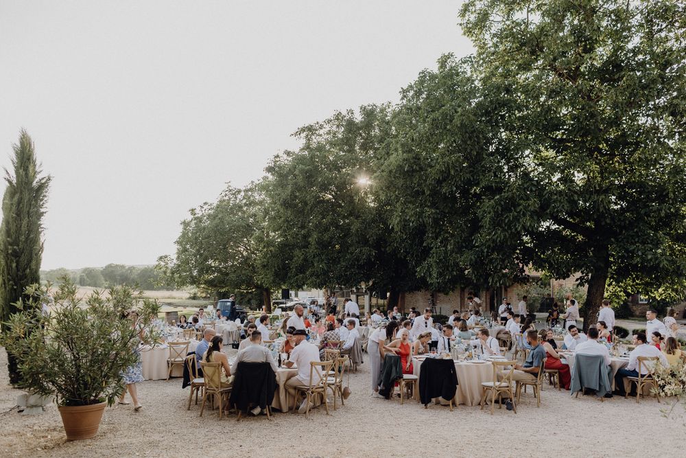 Sommerhochzeit im Hofgut Heidesheim, das Dinner findet unter freiem Himmel im Innehof statt, die Sonne scheint im Hintergrund.