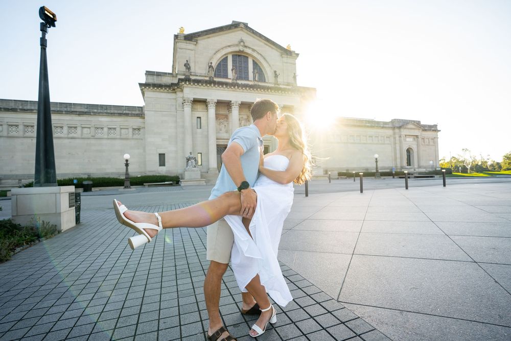 A couple in white outfits dances gracefully on a grand outdoor terrace at sunset in Forest Park, St. Louis, Missouri