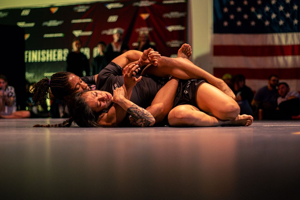 Competitors engage in ground fighting during a professional jiu-jitsu tournament.
