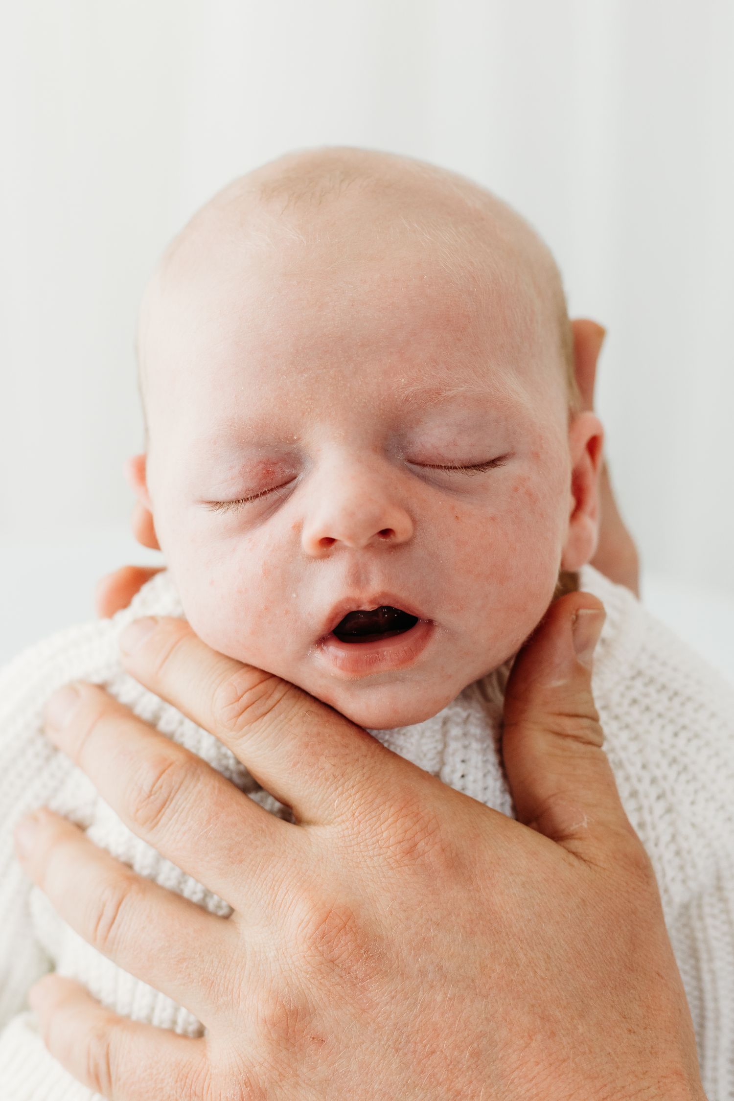 Tiny newborn sleeping during Nottingham photography session, baby wrapped in soft fabric at Mapperley studio.