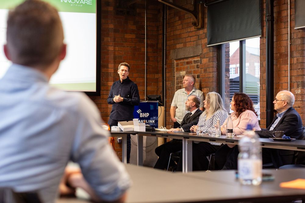 Business professionals collaborate during a meeting in an industrial-style brick office space.