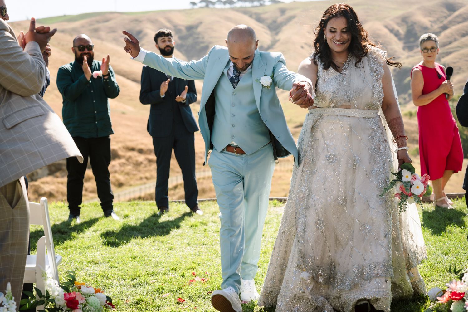 Indian bride and groom walking hand in hand after their first kiss at Ohariu Farm wedding in Wellington