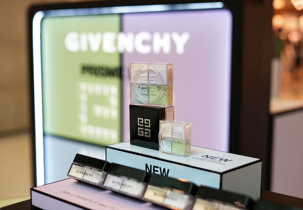 Givenchy beauty product display with illuminated brand logo and cosmetic testers.