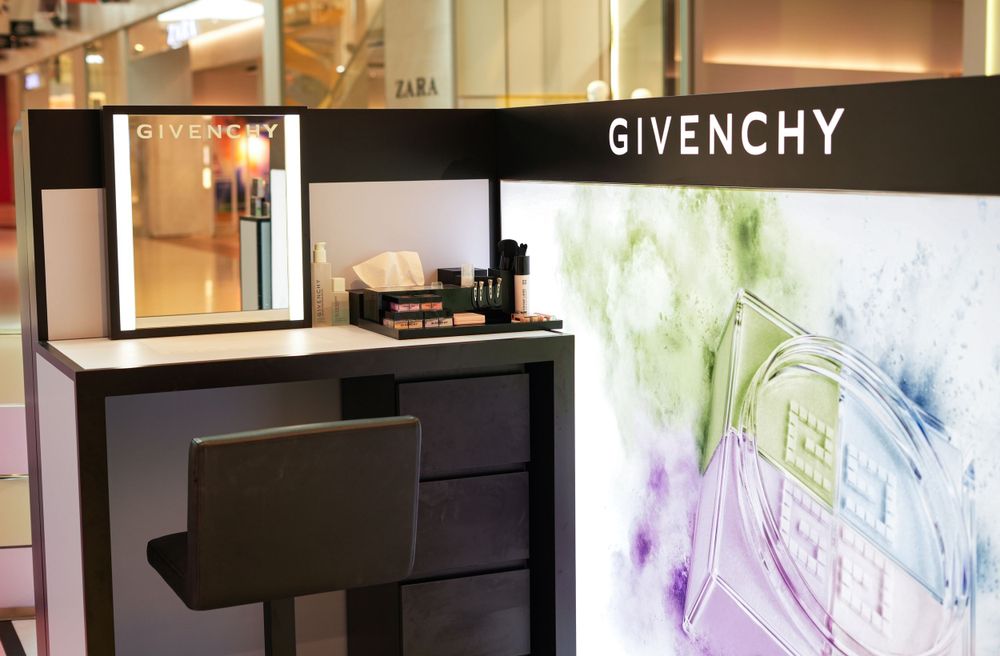 Givenchy luxury makeup counter display with vanity mirror and drawers in a retail store.