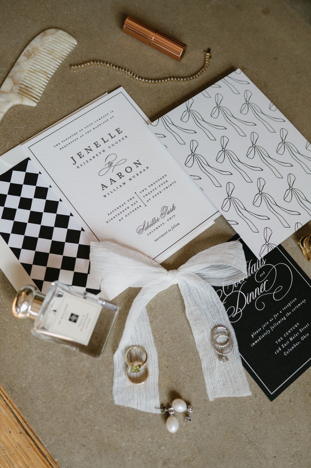 Stylish wedding invitation suite with black and white design elements and personal accessories.