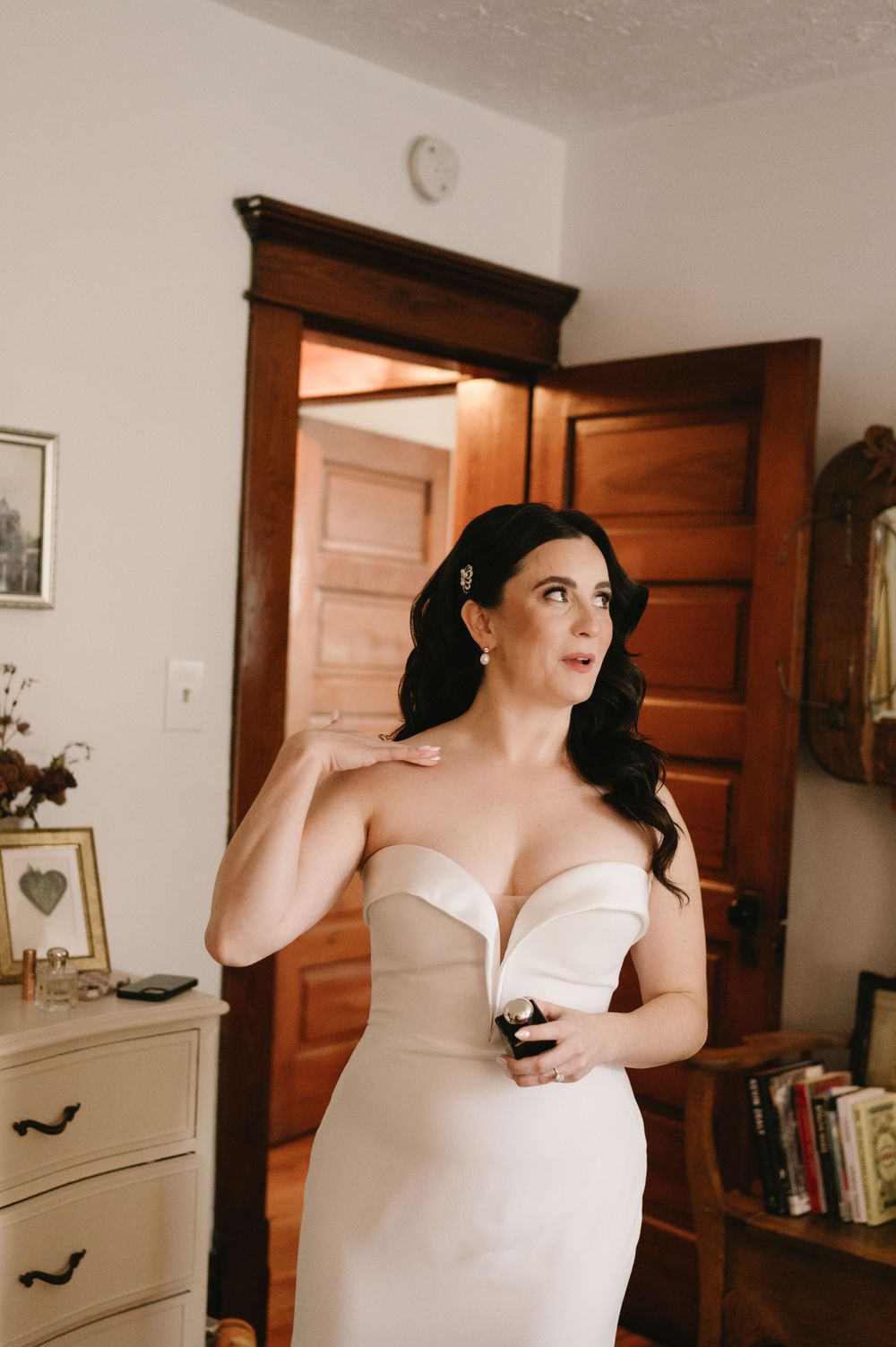Classic white wedding gown shown against warm wooden door backdrop.