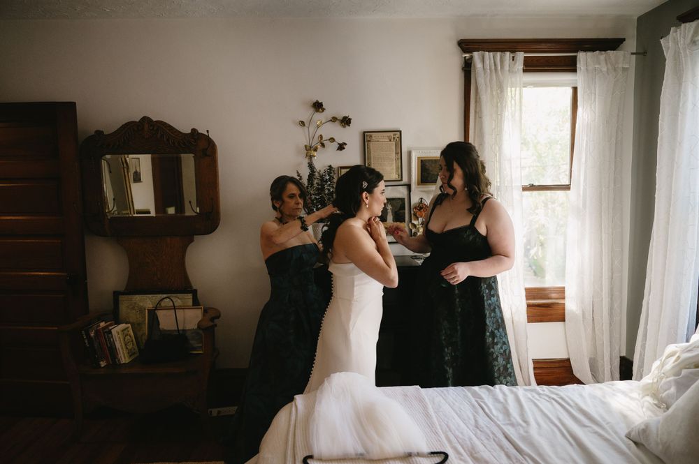 Wedding preparation candid moment in vintage-styled bedroom with natural light.