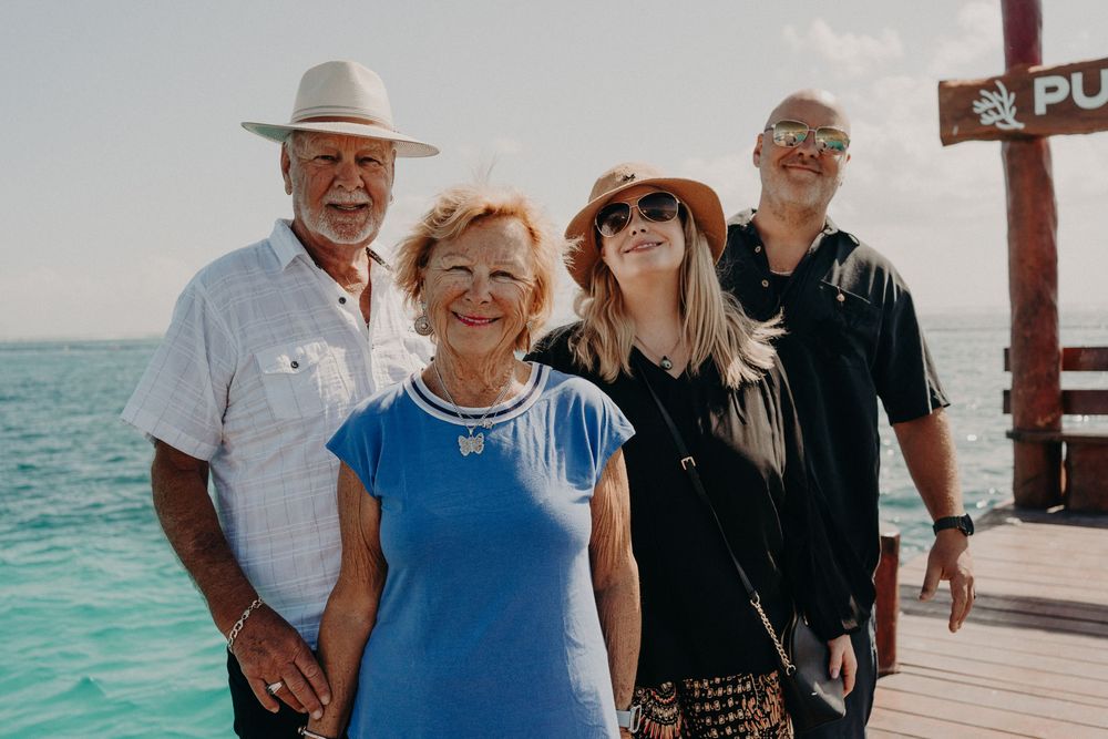 Group of people enjoying a sunny day at a tropical dock with turquoise waters in the background.