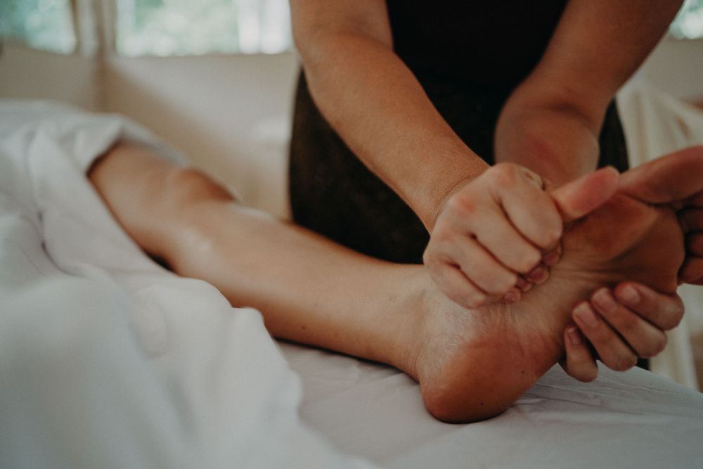 Detailed view of a foot massage therapy session with therapist's hands working on client's sole photoshoot in Puerto Morelos.