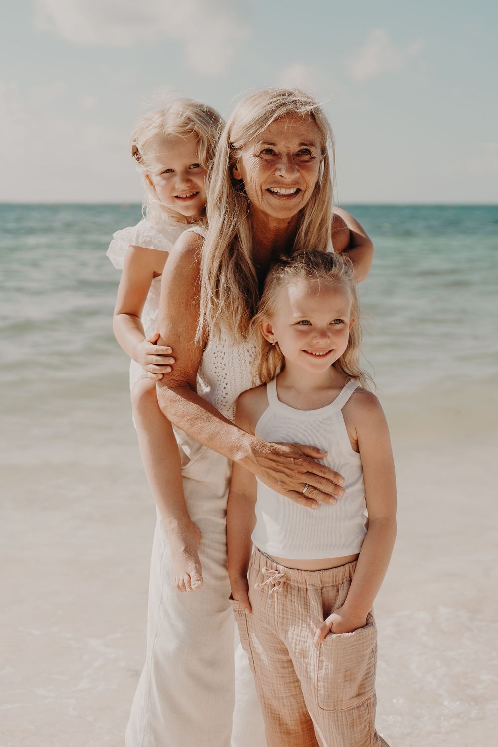 Family beach portrait with light-filled tropical ocean backdrop photoshoot in Puerto Morelos.