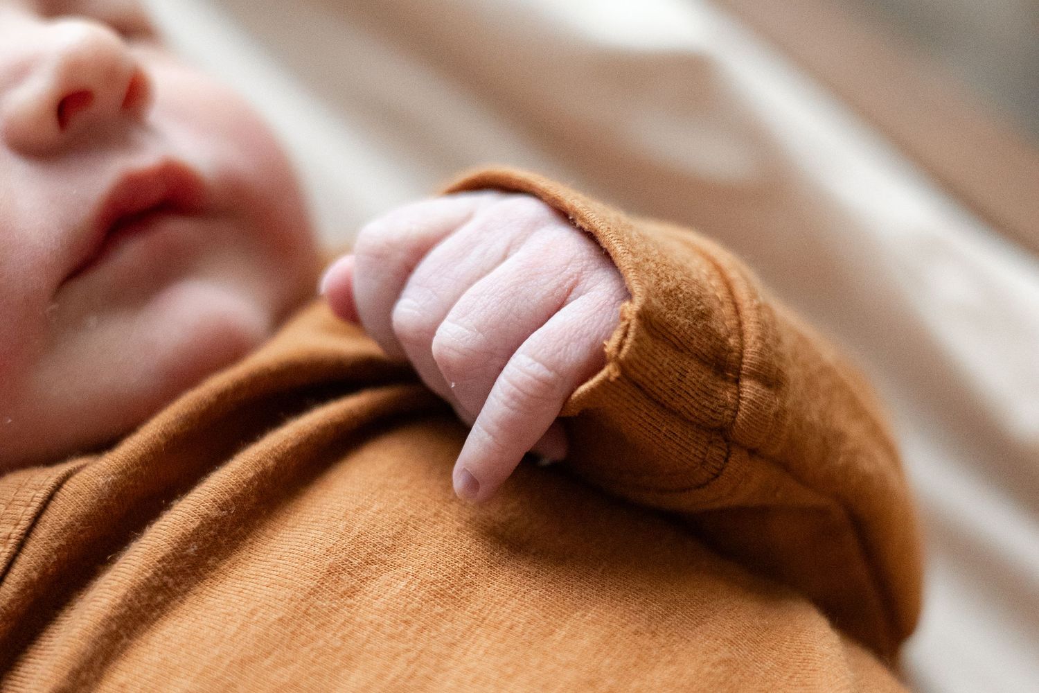 Close up of a baby's fingers laying on their chest
