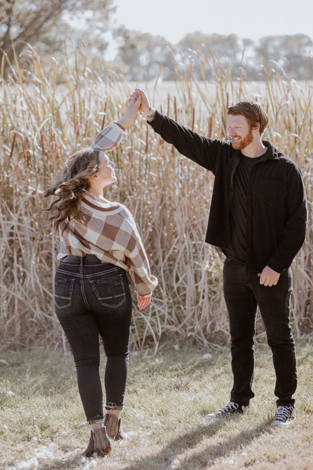 Couple dances together near a field outside
