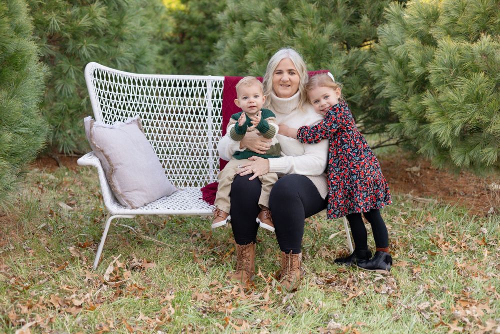 Grandma and two grandkids cuddle on a white bench in Springfield, IL