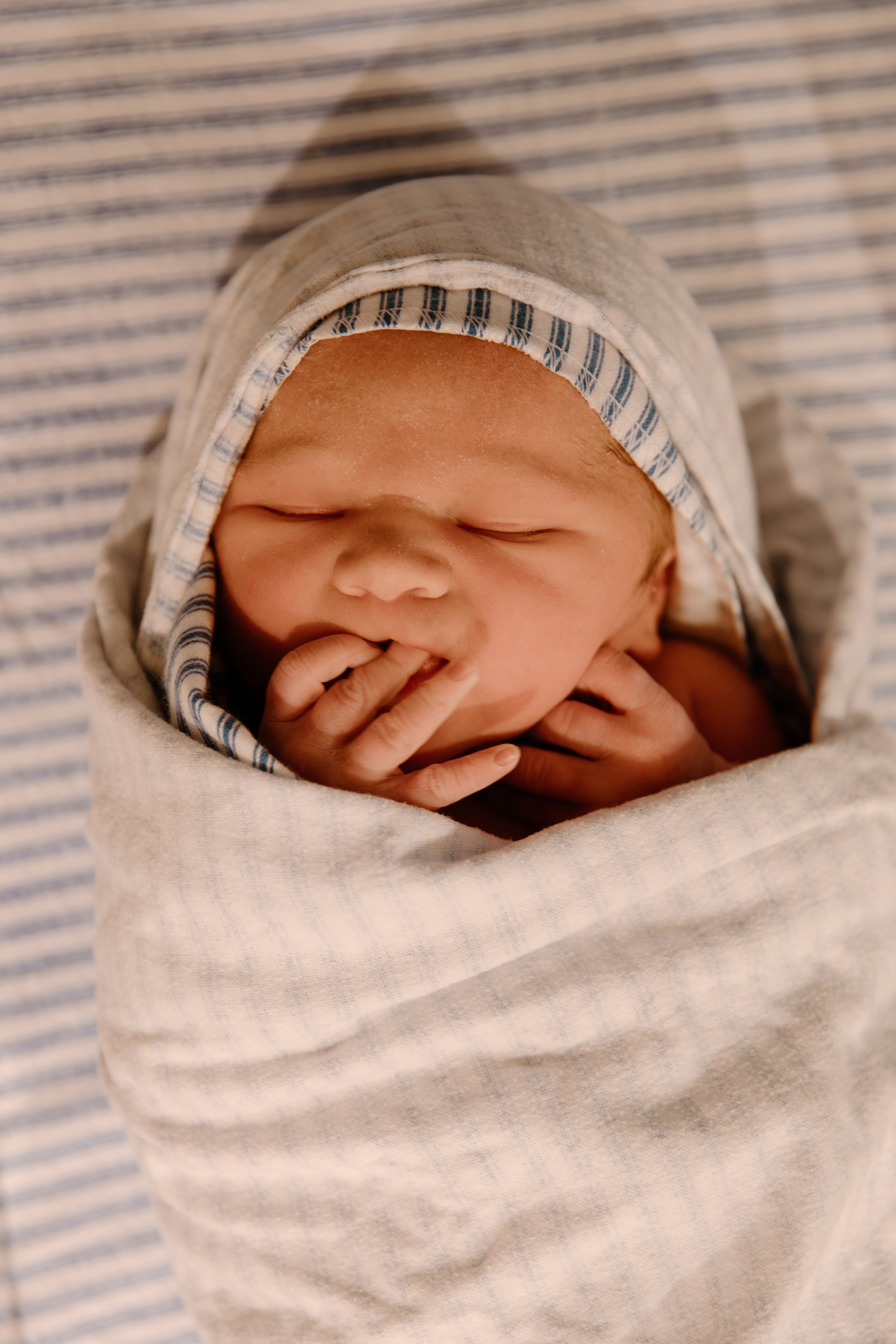 A newborn baby is wrapped up in blankets and asleep during a newborn photography shoot in Karratha