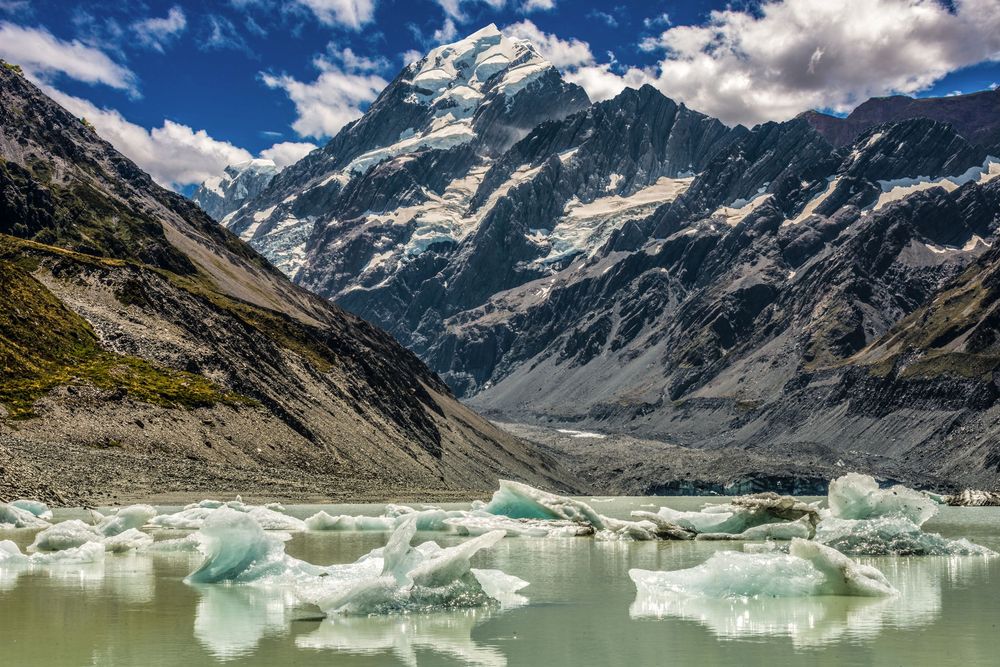 Panoramic view of Hooker Lake with floating icebergs and Mount Cook rising dramatically in the background.