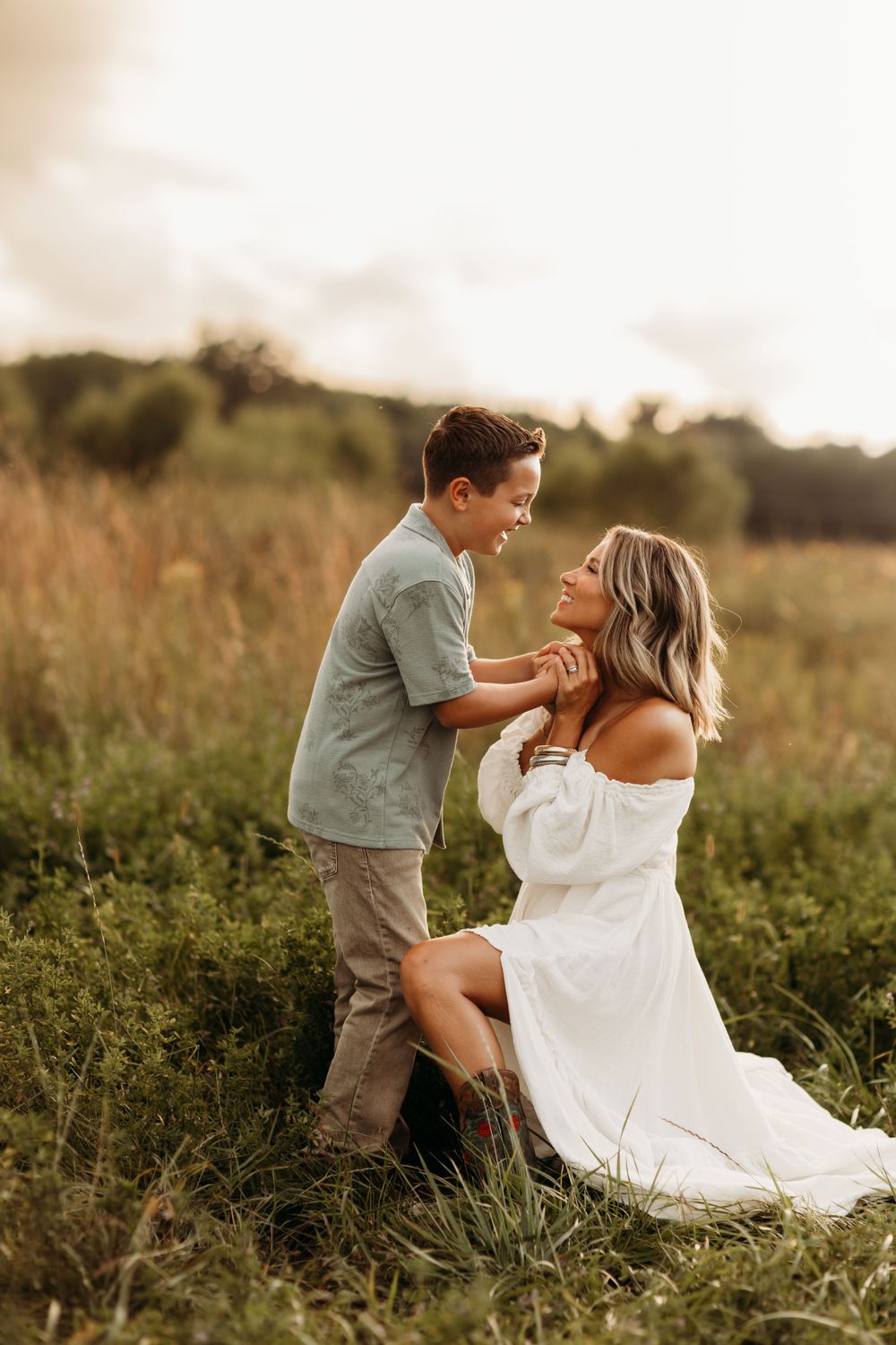 A touching moment between two people in a sun-drenched field during golden hour.