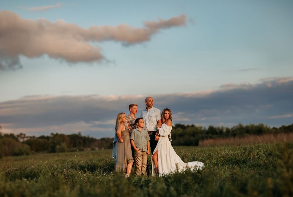 Family portrait session captured during golden hour in a natural outdoor setting.