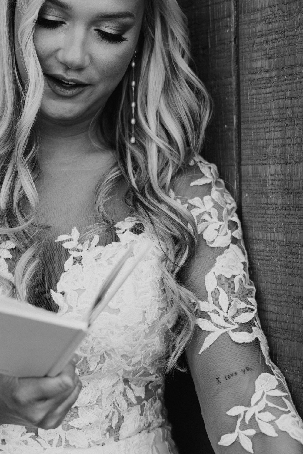 During the first touch, a close-up showing delicate floral lace details on a white wedding dress with her tattoo framed beautifully.