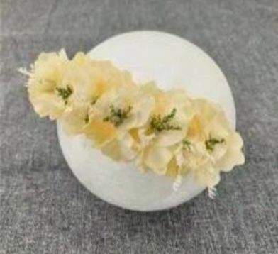 Delicate yellow floral hair accessories arranged on gray surface.