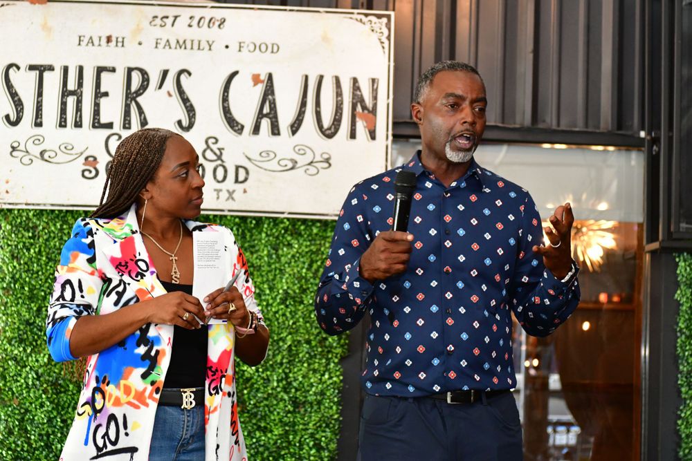 Two presenters speak at Esther's Cajun restaurant event wearing polka dot and patterned outfits.
