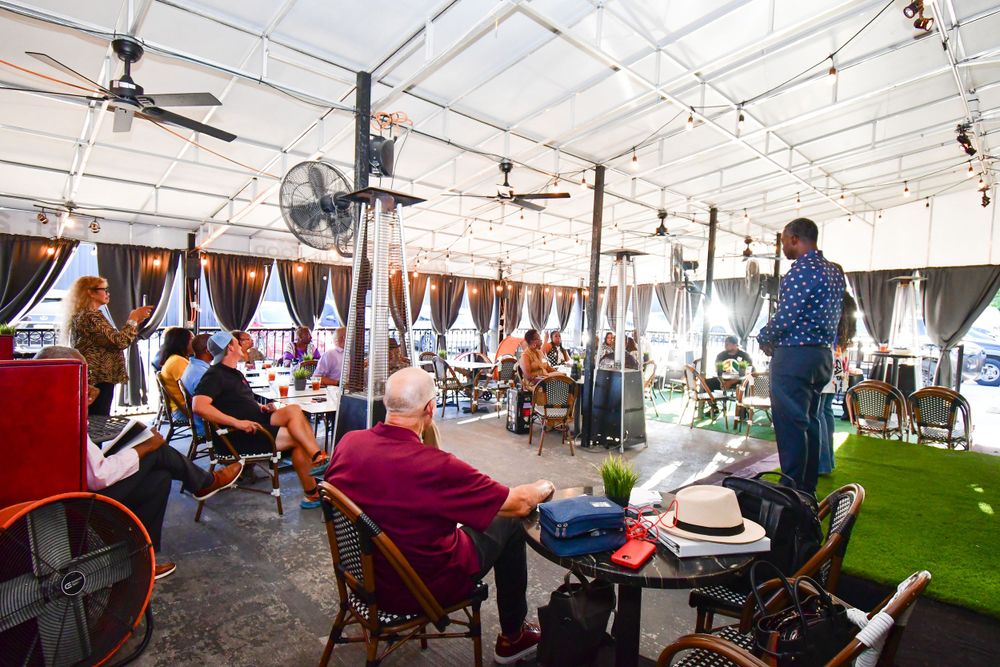 Indoor dining space with ceiling fans, drapes, and artificial turf flooring.