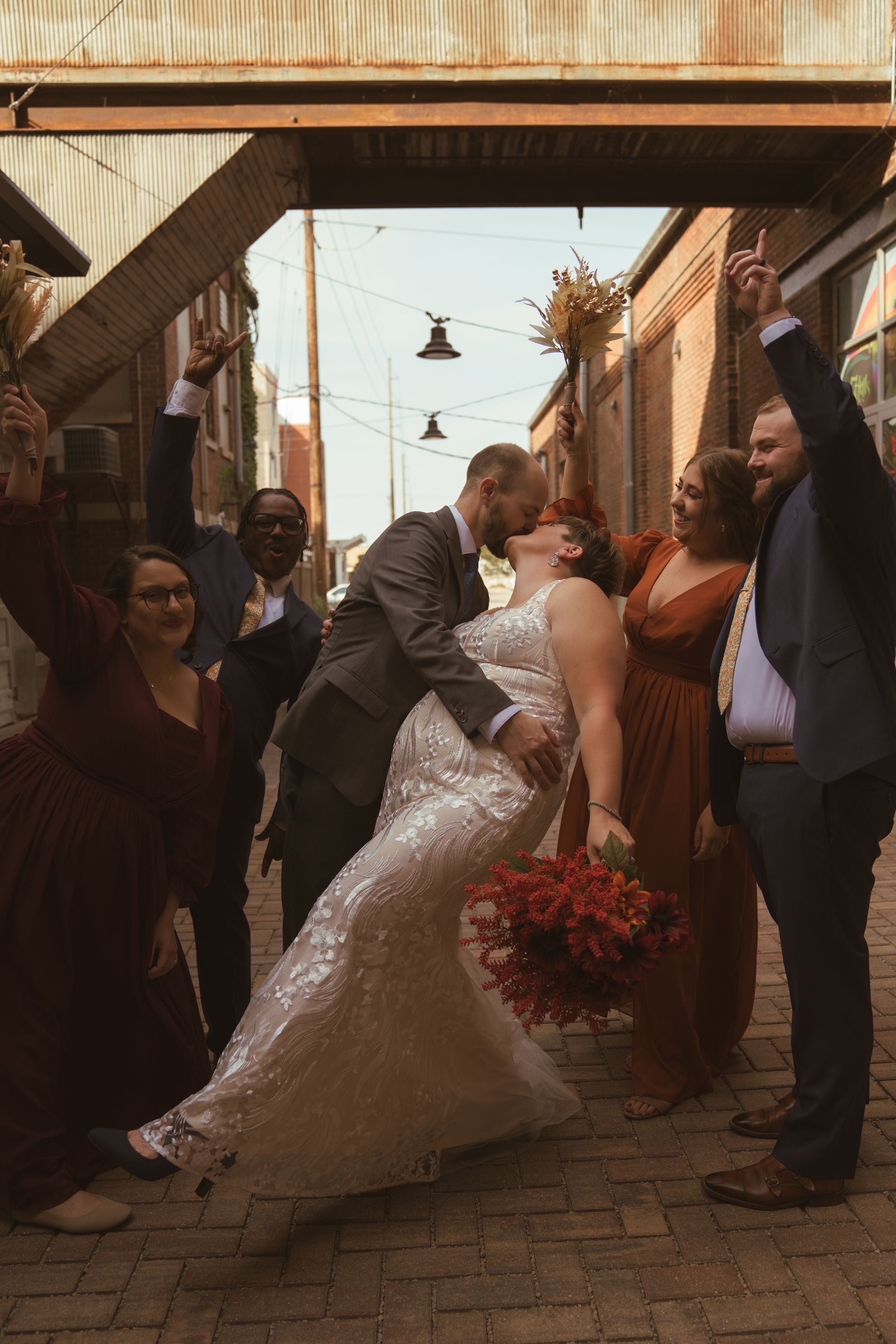 A wedding celebration outside a rustic building with warm autumn lighting.