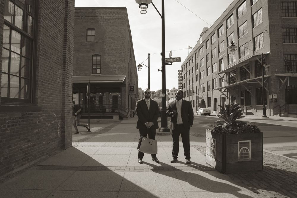 Black and white urban street scene with industrial brick buildings and vintage atmosphere.