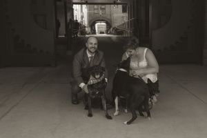 Black and white photo of wedding party members sitting on concrete steps.