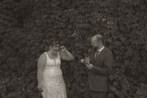 Wedding couple sharing an intimate moment against dark foliage background.