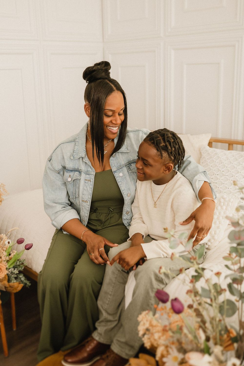 A tender moment shared between parent and child sitting together on a couch with floral decorations nearby.
