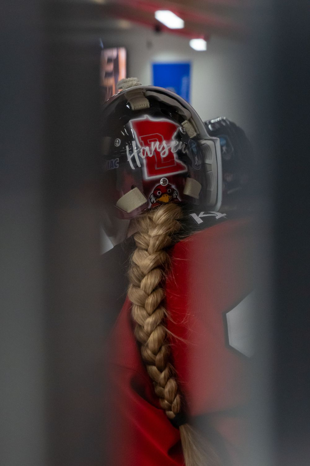 A long blonde braided ponytail hangs down from a black Hype-branded helmet against a blurred background.
