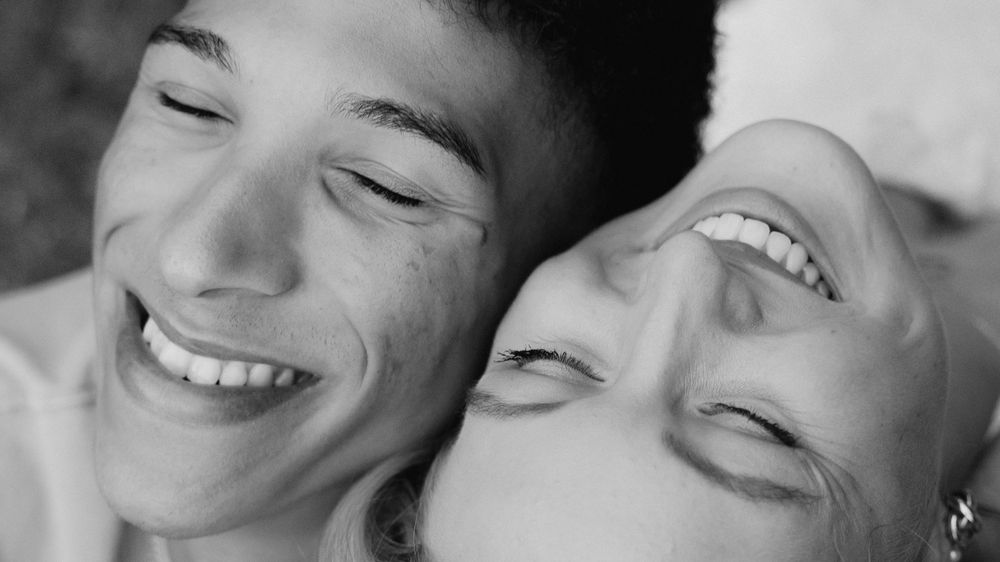 A collection of black and white close-up photos showing joyful expressions and genuine smiles.