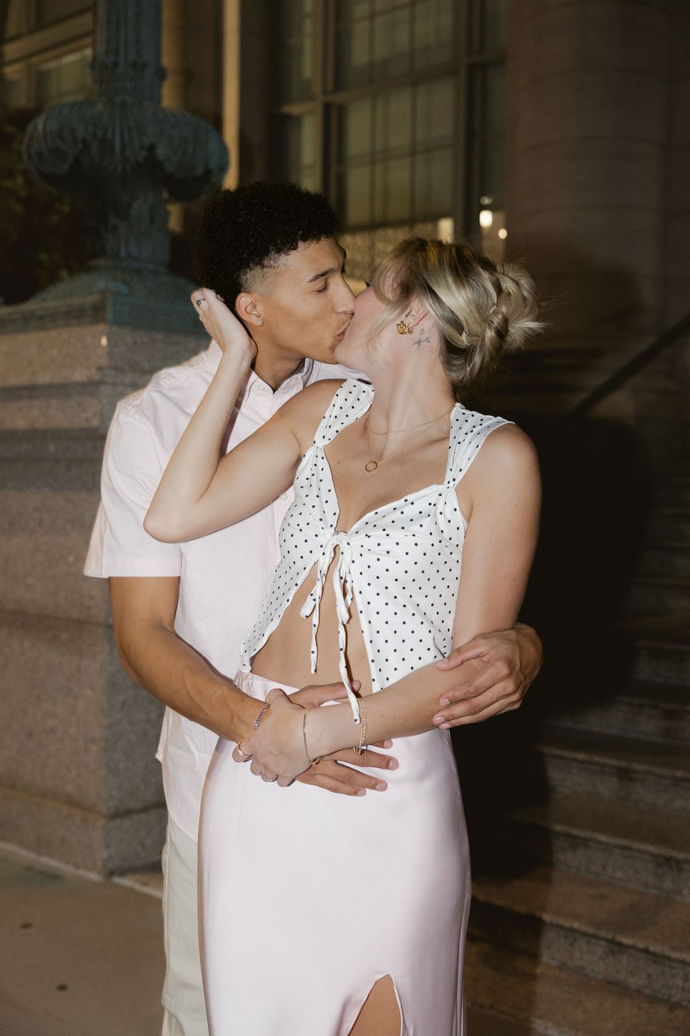 A romantic couple in white outfits share intimate embraces in a series of tender moments against a dark background.