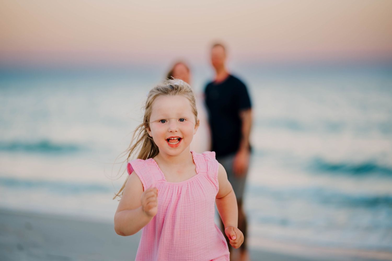Little girl running on a beach during lifestyle family photoshoot