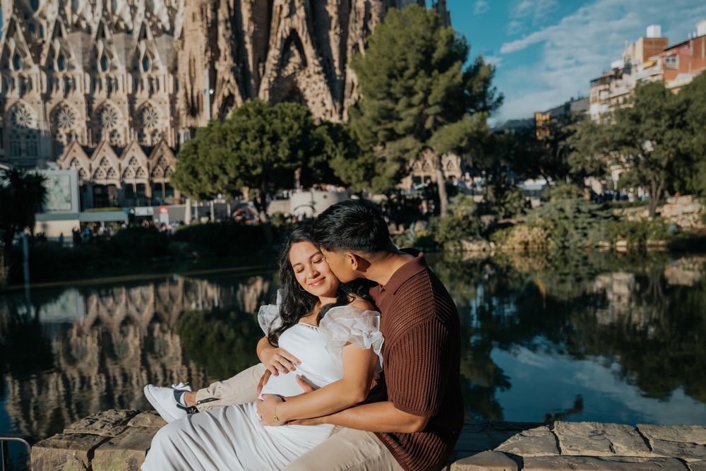Pregnant couple cuddling in soft morning light