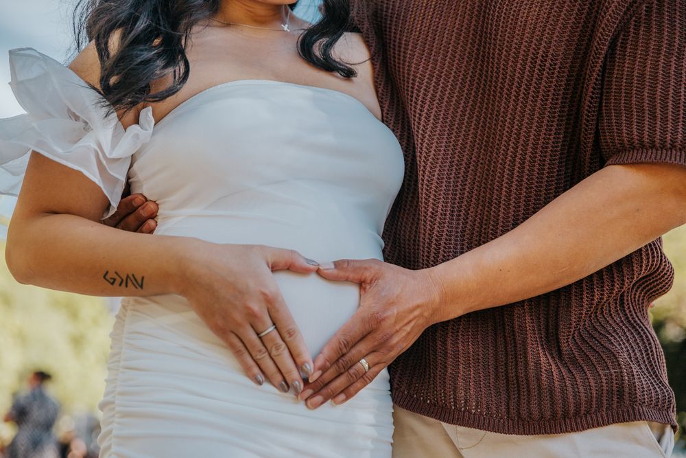 Holding hands and smiling during babymoon session