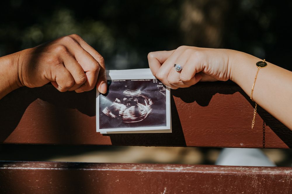 Family-to-be with architectural wonder behind