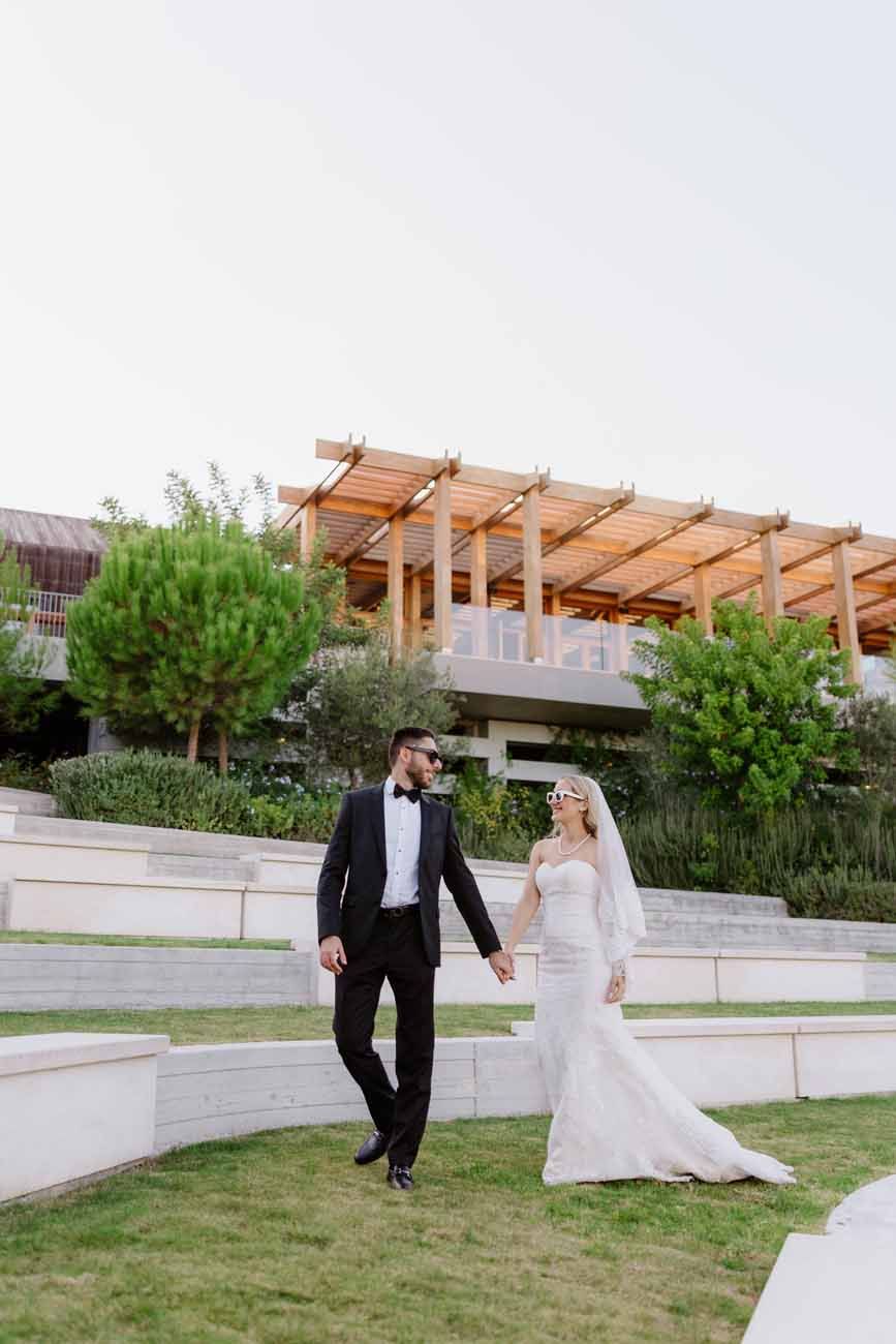 A newlywed couple dances outdoors at night with dramatic pyrotechnic fountains illuminating their special moment.